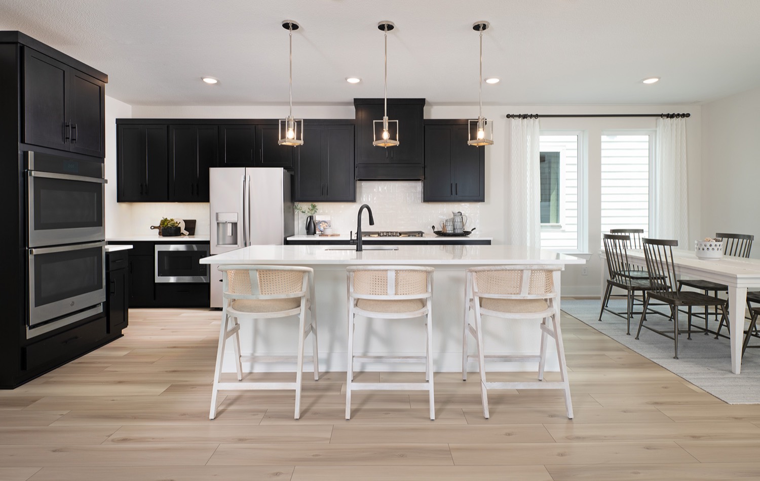 Modern kitchen remodel with black cabinets and quartz island